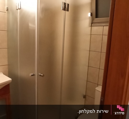מקלחון זכוכית עם דלתות מתכת בחדר אמבטיה